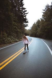 Full length rear view of man walking on road