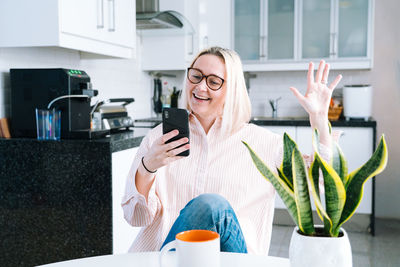 Laughing woman talking on video call at home