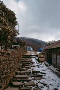 Houses by building against sky during winter