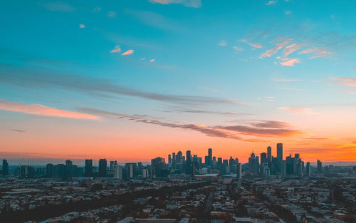 Aerial view of modern buildings against sky during sunset