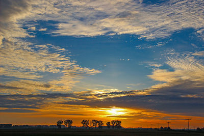 Scenic view of silhouette land against dramatic sky during sunset