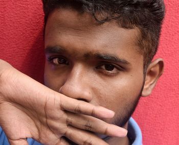 Close-up portrait of young man against wall