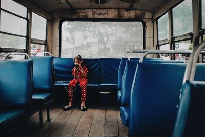 Rear view of woman sitting in train