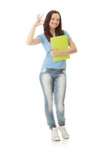 Portrait of smiling young woman standing against white background