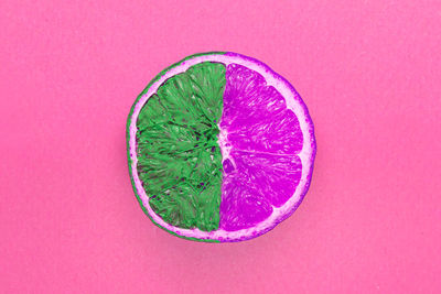 Directly above shot of lemon slice against pink background