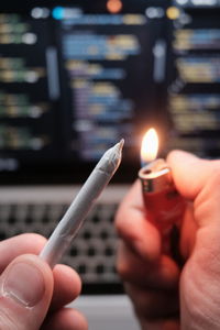 Close-up of hand holding cigarette