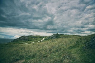 Scenic view of field against cloudy sky