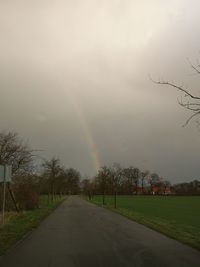 Scenic view of rainbow over road against sky