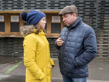 Father talking with daughter while standing on street