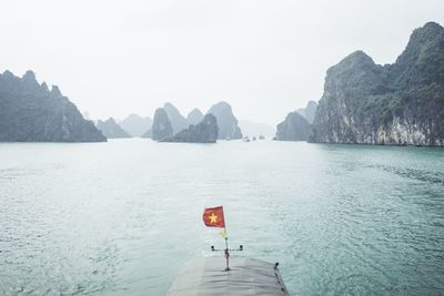 Scenic view of sea and mountains against clear sky