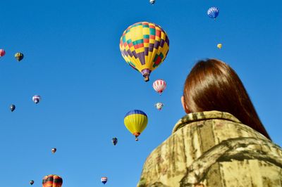 Low angle view of hot air balloons against blue sky