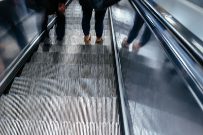 Low section of people standing on escalator