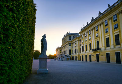 Statue amidst buildings against sky in city