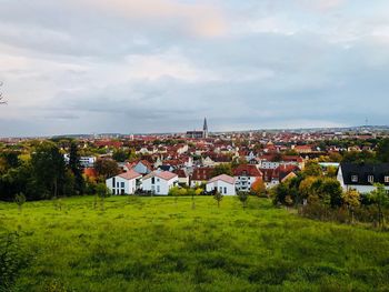 Houses on field in town against sky