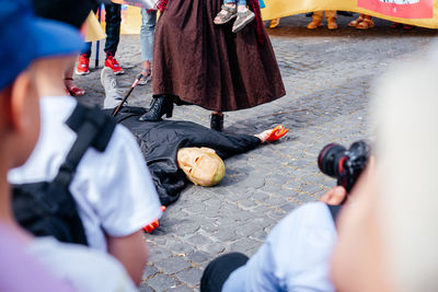 Rome, italy - may 22, 2022 a man wearing a mask of putin lying on the ground at anti-war protest in