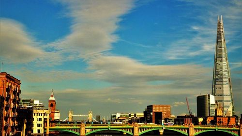 Buildings in city against cloudy sky