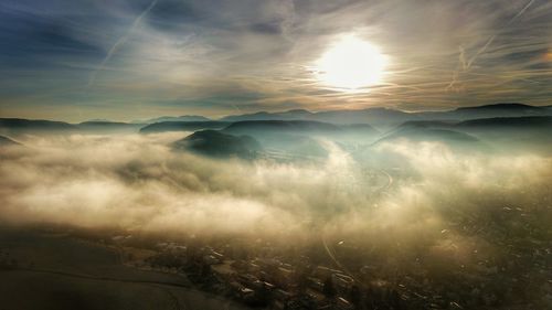 Sunlight streaming through clouds over landscape