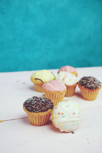 Close-up of cupcakes on table against wall