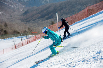 People skiing on mountain during winter