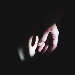 Close-up of hands against black background