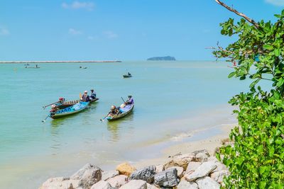 People on sea against sky