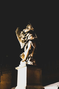 Low angle view of angel statue at night