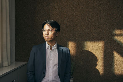 Young man standing against wall