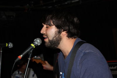 Midsection of man playing guitar at music concert