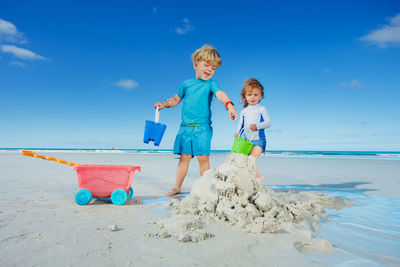 Portrait of siblings playing on beach