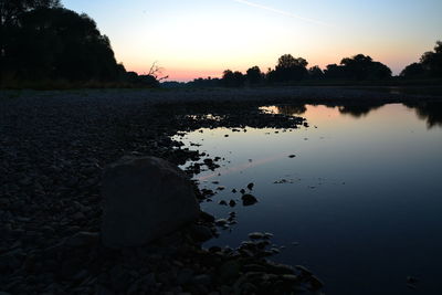 Scenic view of lake against sky at sunset