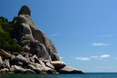Rocks on sea shore against sky
