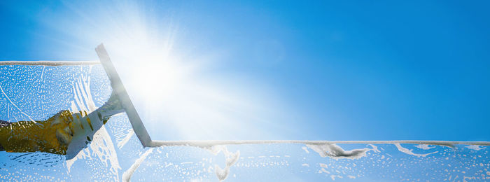 Low angle view of frozen lake against blue sky