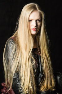 Portrait of beautiful woman against black background