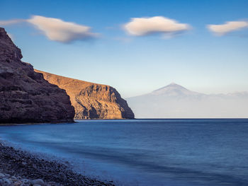 Rock formations by sea against sky