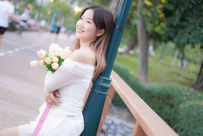 Portrait of smiling young woman holding bouquet