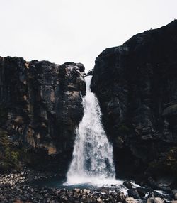Scenic view of waterfall against sky