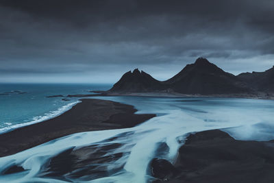 Scenic view of sea and mountain against sky