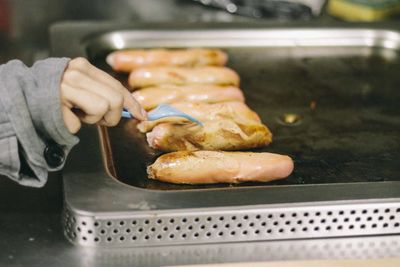 Cropped hand holding sausage with fork