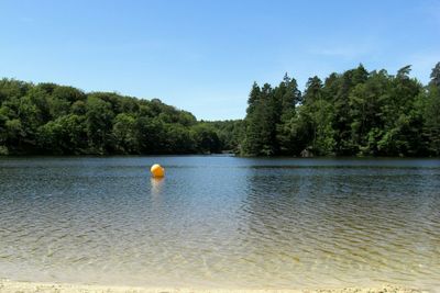 Swimming pool in lake against clear blue sky