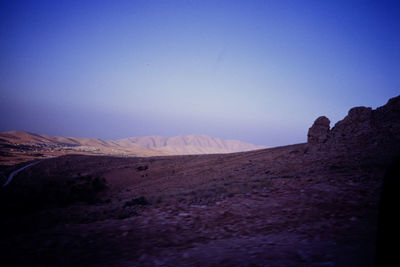 Scenic view of desert against clear blue sky