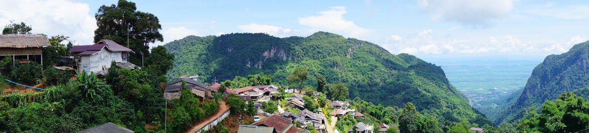 Panoramic view of trees and buildings against sky