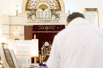 Jewish worship activities in a synagogue focus on torah scrolls, prayer, community, and faith