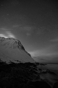 Scenic view of snowcapped mountains against sky at night