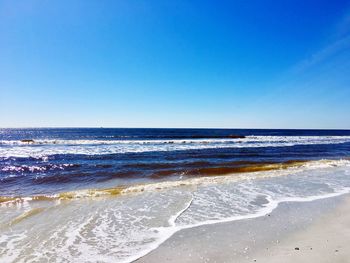 Scenic view of sea against clear blue sky