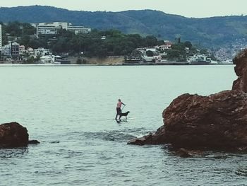 Man in sea against mountains