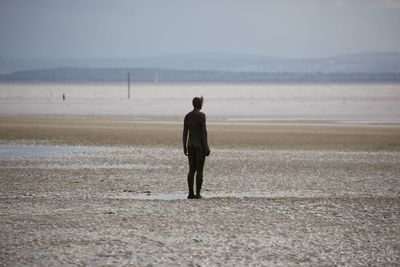 Rear view of man standing on beach