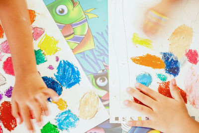 Cropped image of child with drawings on paper
