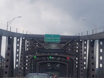 Cars on road against sky in city