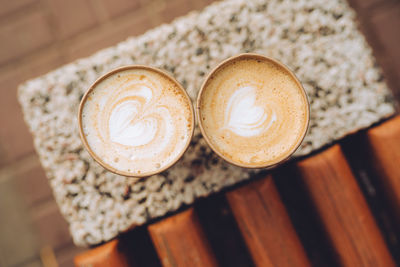 Two paper cups of cappuccino with latte art. beautiful foam, coffee to go