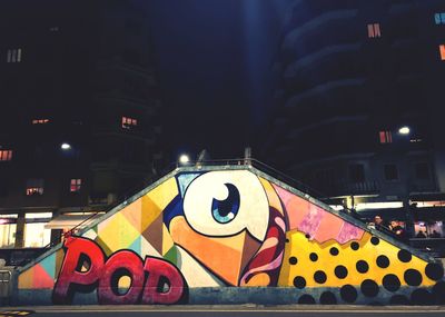 Graffiti on illuminated building in city at night